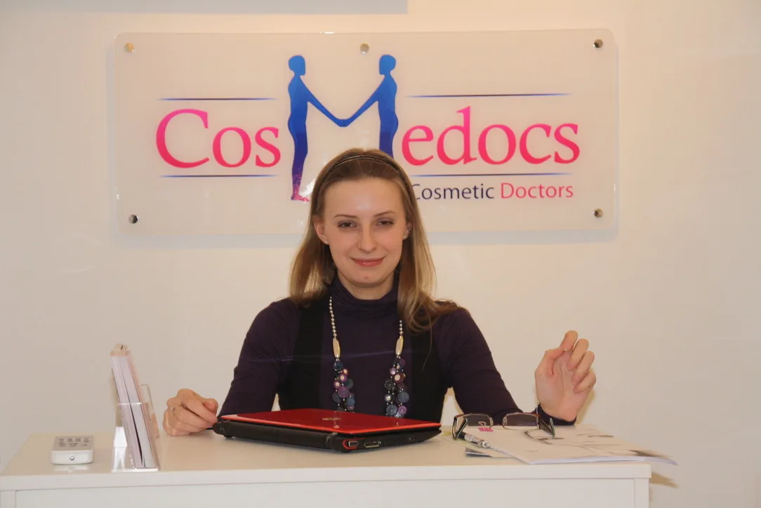 Cosmedocs original reception desk on Harley Street in the early years, with the founding 'CosMedocs Cosmetic Doctors' logo on the wall