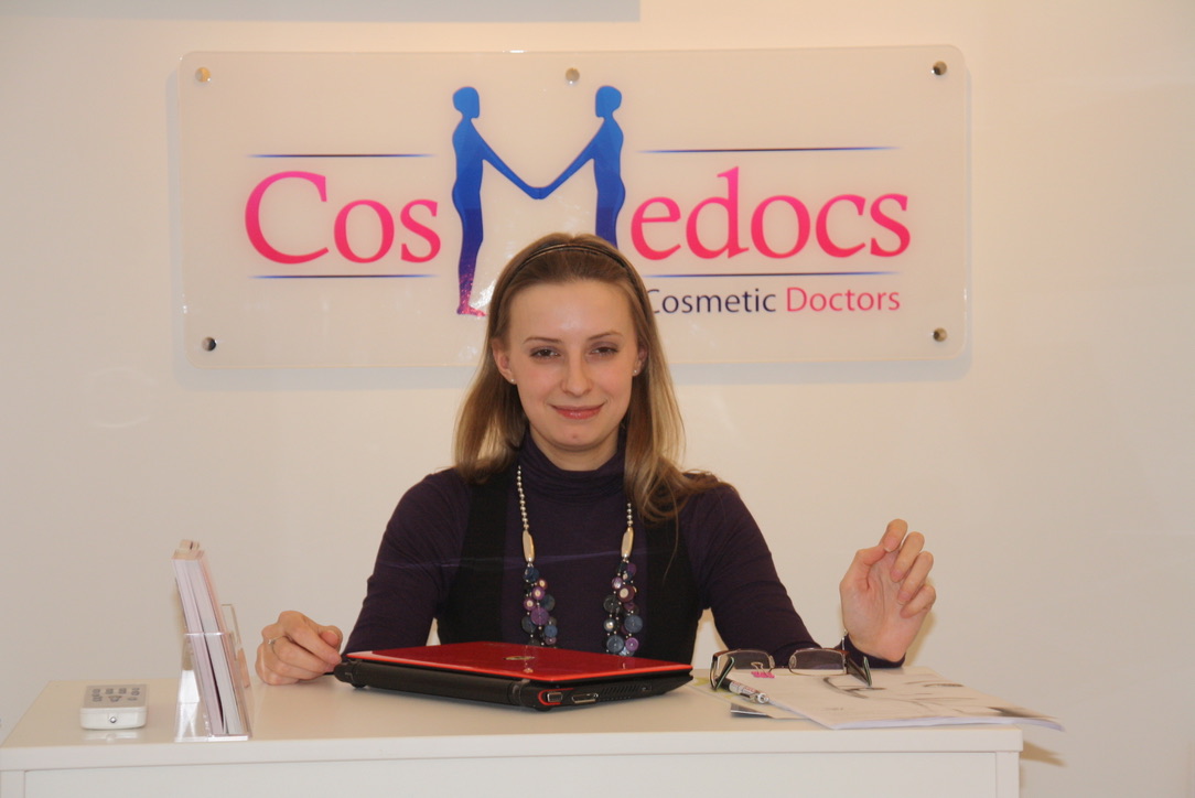 Cosmedocs original reception desk on Harley Street in the early years, with the founding 'CosMedocs Cosmetic Doctors' logo on the wall